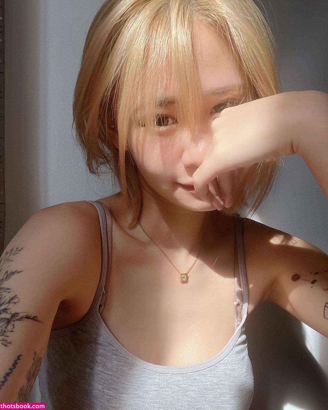 A thoughtful expression lost in contemplationA quiet beauty that speaks volumesA delicate hand resting on soft skin